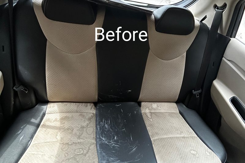 Before interior detailing — dark scuffed stains on rear bench seat